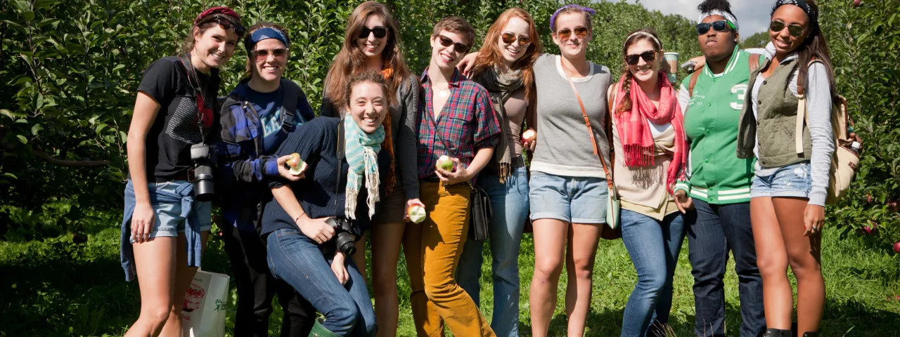 A group of students picking apples on Mountain Day.