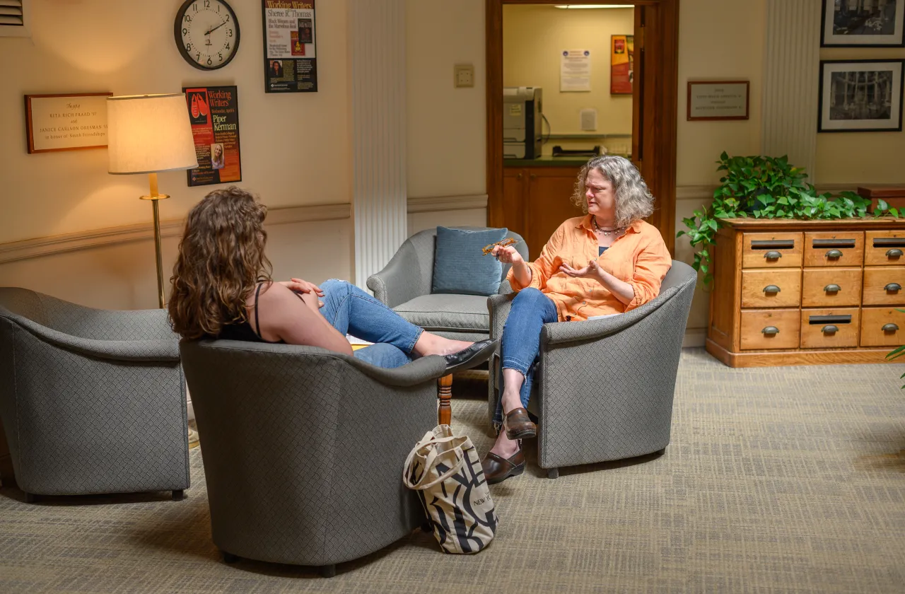 A student and writing instructor talking.