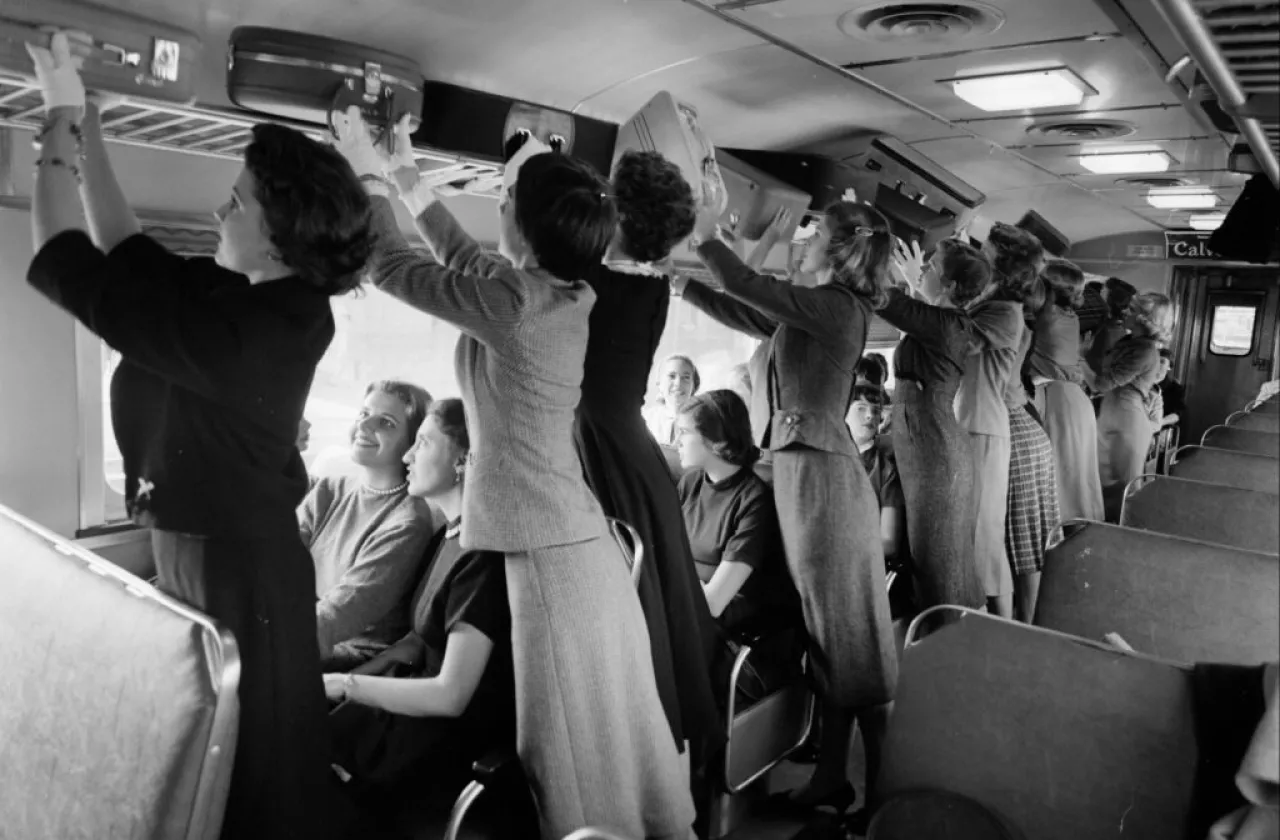 Smith students practicing their luggage lifting skills on a train in the 1950s.