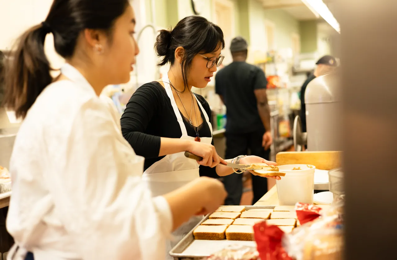 A student prepares food for IS Day 2025.