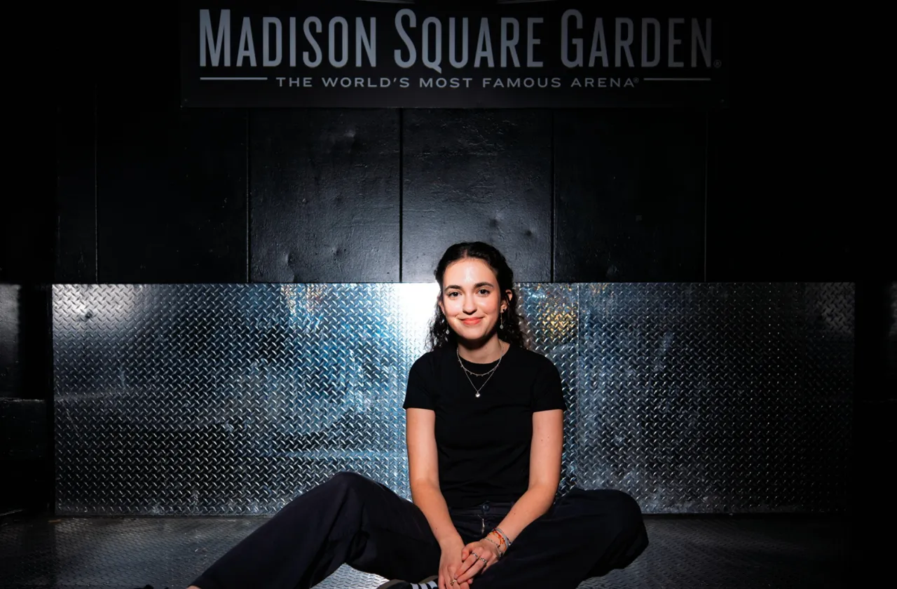 Elie Pichanick sits in front of a wall bearing the Madison Square Garden logo