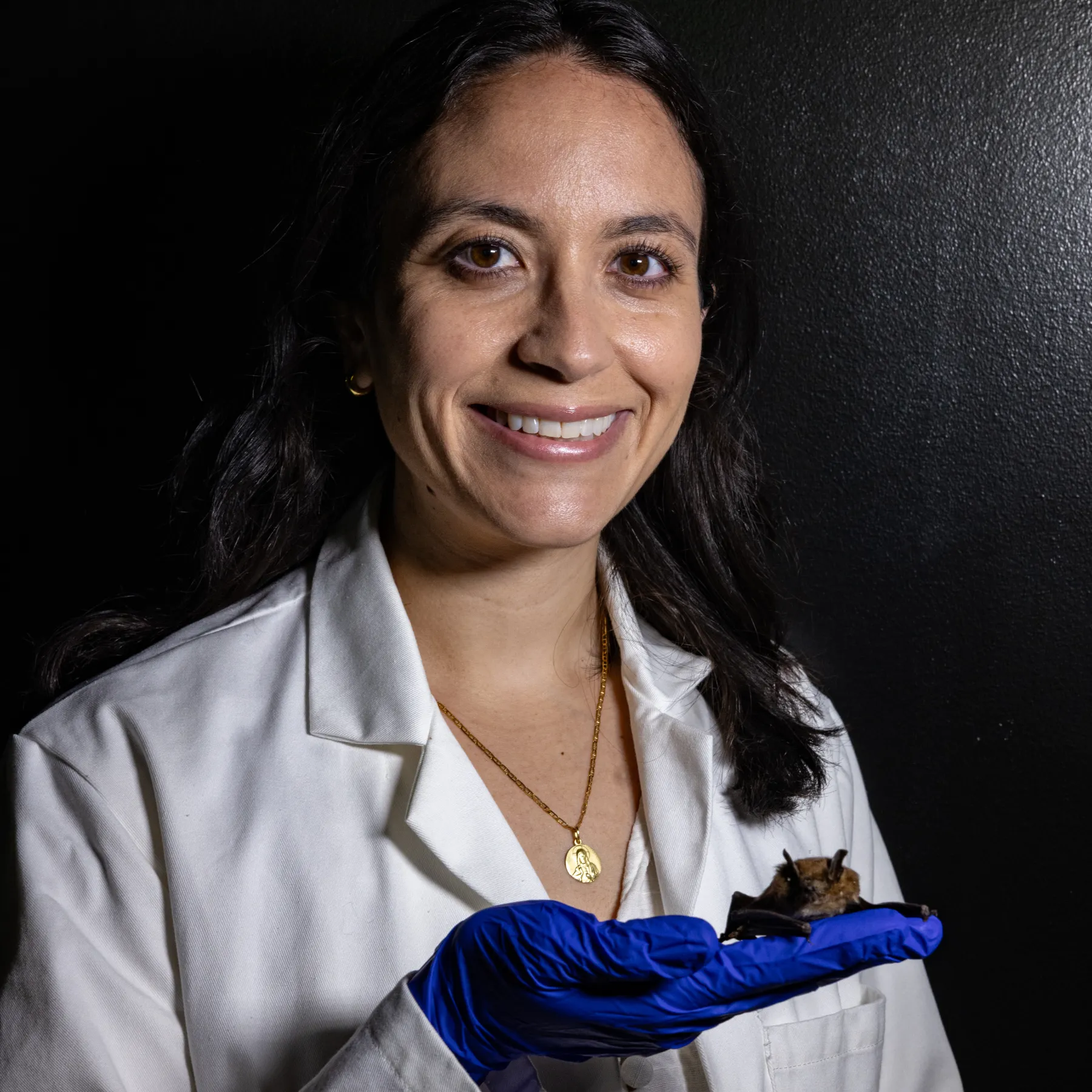 Professor Tanya Lama holds a bat in her gloved hand