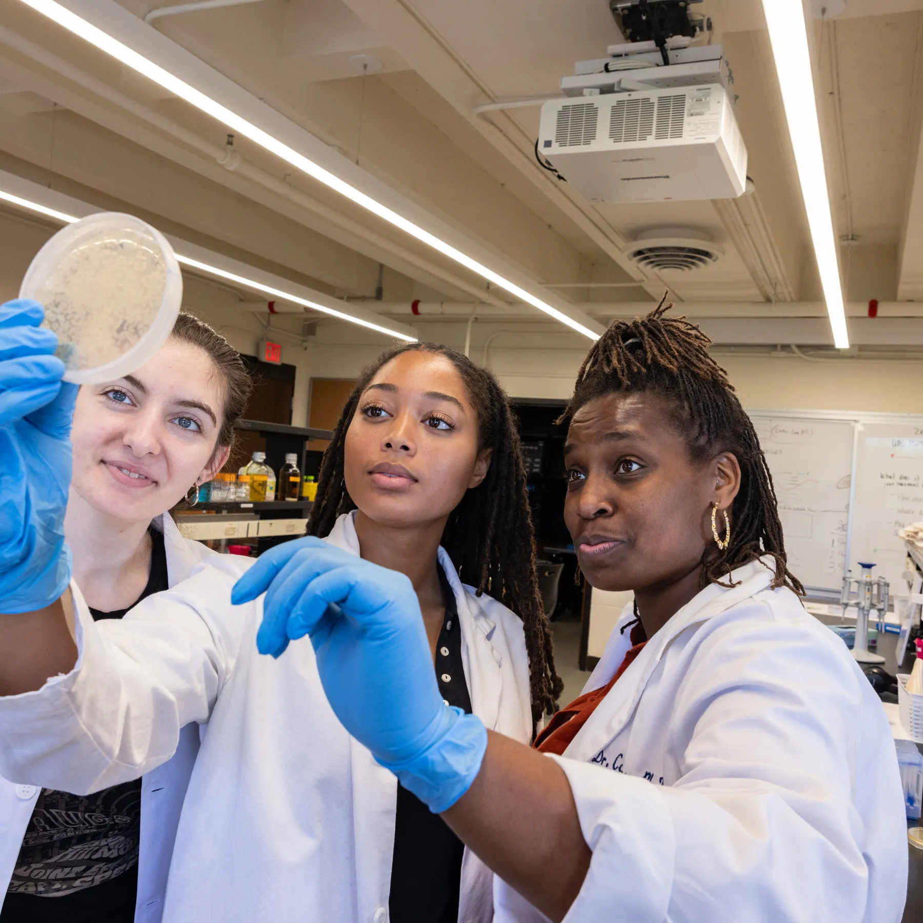 Students Mia Boydston and Zelah Booker and assistant professor Cagney Coomer in a lab.