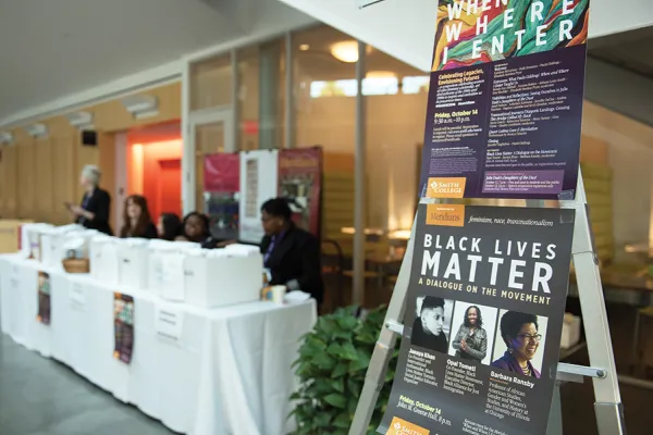 Conference registration table in the Campus Center with posters for the Meridians event