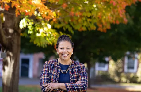 Sarah Willie-LeBreton stands under a tree in the fall at Smith College