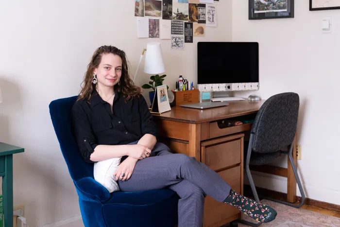 Sophia sitting in a chair next to her desk.