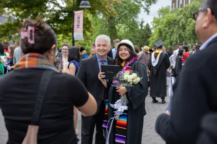 A student smiles with a family member during Commencement