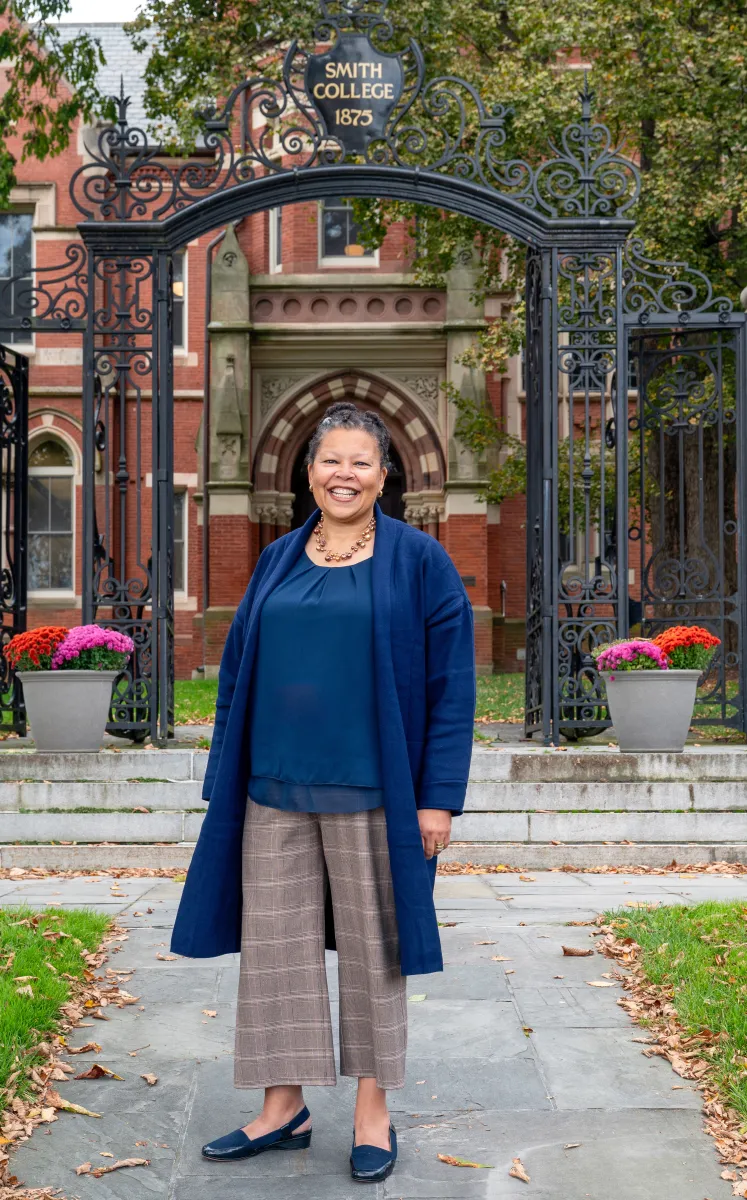 Sarah Willie-LeBreton smiling and standing outside of College Hall. 