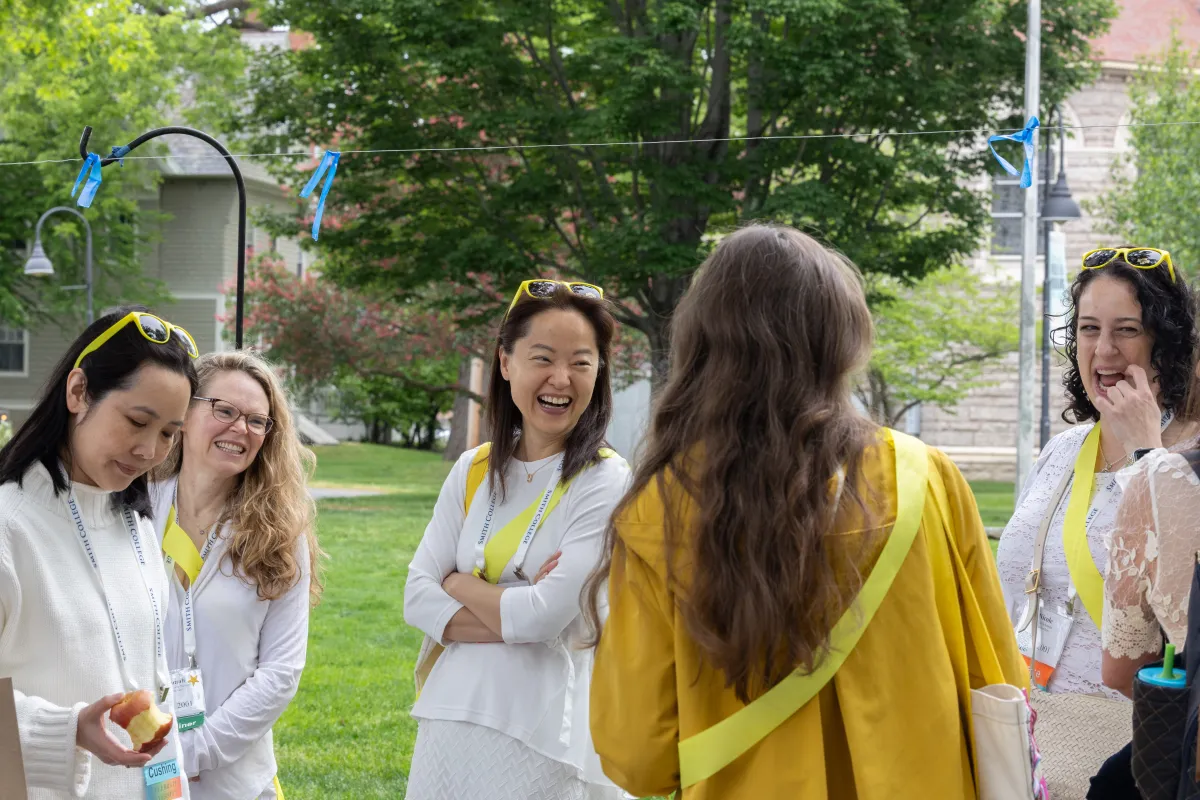 Smithies in white wearing yellow sashes laugh during Reunion