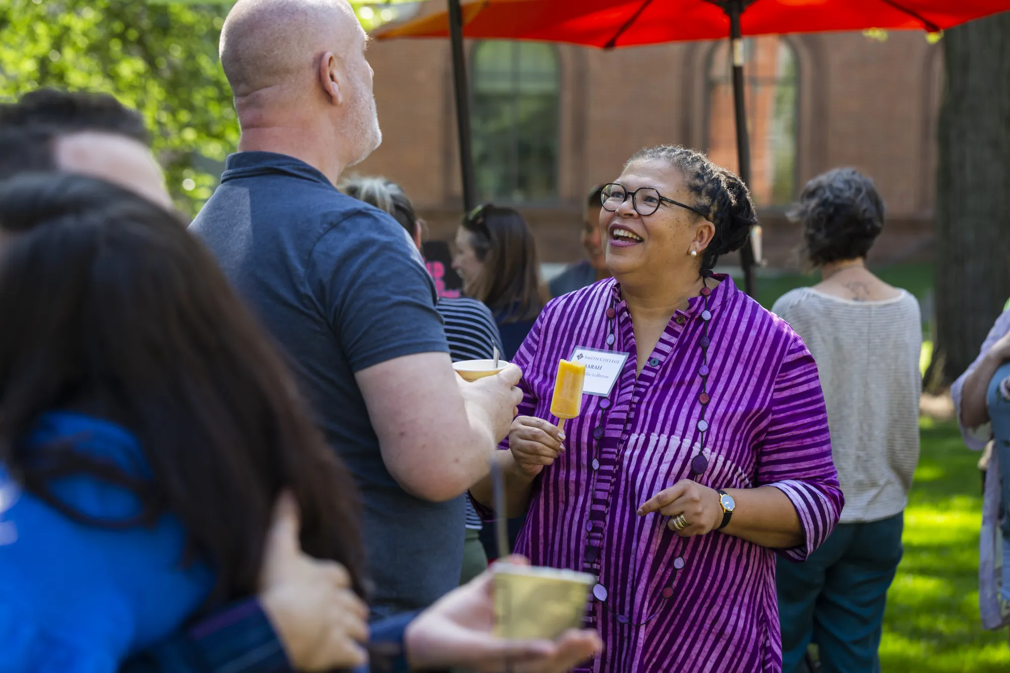 Sarah Willie-LeBreton holding a popsicle at an ice cream social on campus.