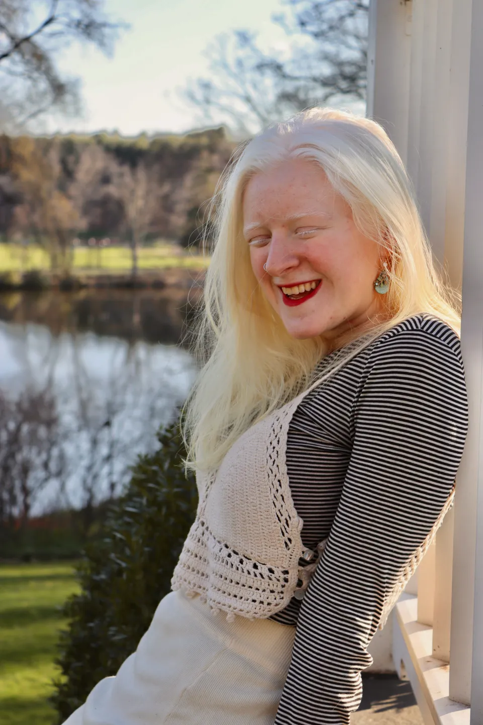 Una Fonte smiles in a portrait while wearing a white and striped top