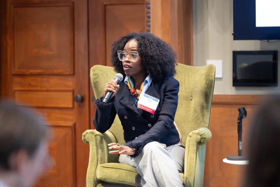 Smith College alum Nicole Kenney speaks while sitting on a high-backed chair.
