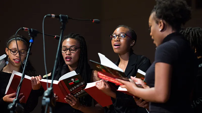 Four students singing on stage at Otelia Cromwell Day