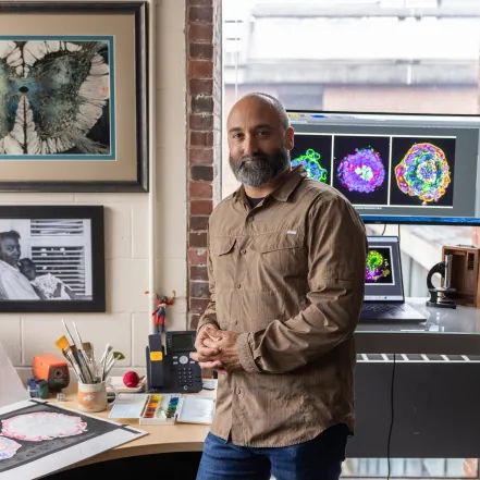 Michael Barresi in front of computer screens and an art pad.