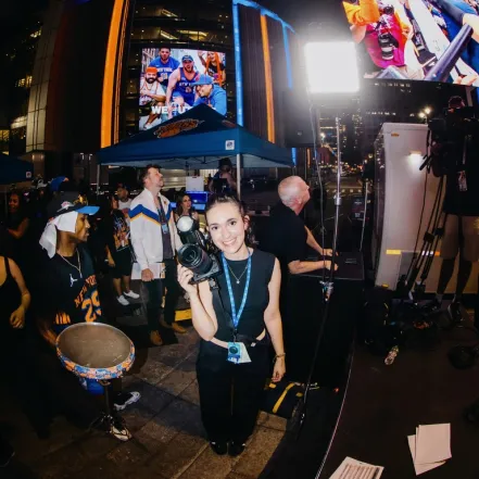 Elie Pichanick smiles for a photo while holding up her own camera during a New York Knicks watch party.