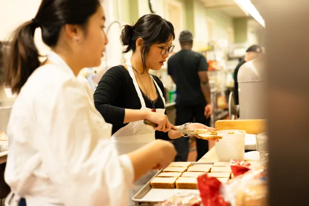 A student prepares food for IS Day 2025.