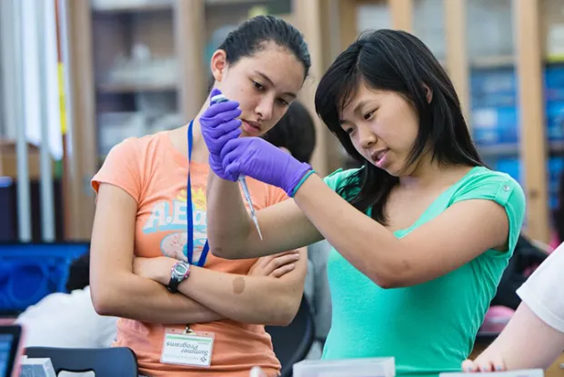 Two high school students looking at a syrninge at the Summer Science & Engineering Program at Smith